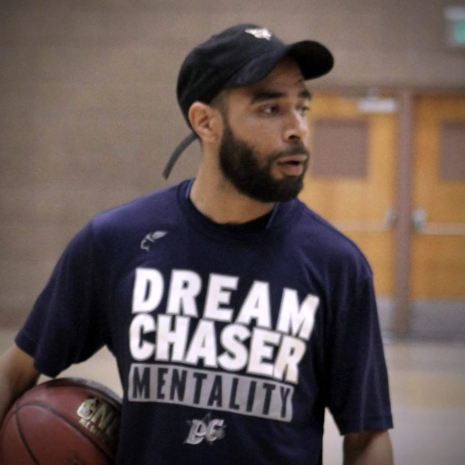Coach Jelani Hicks, founder and head coach of Dream Chaser Elite, holding a basketball